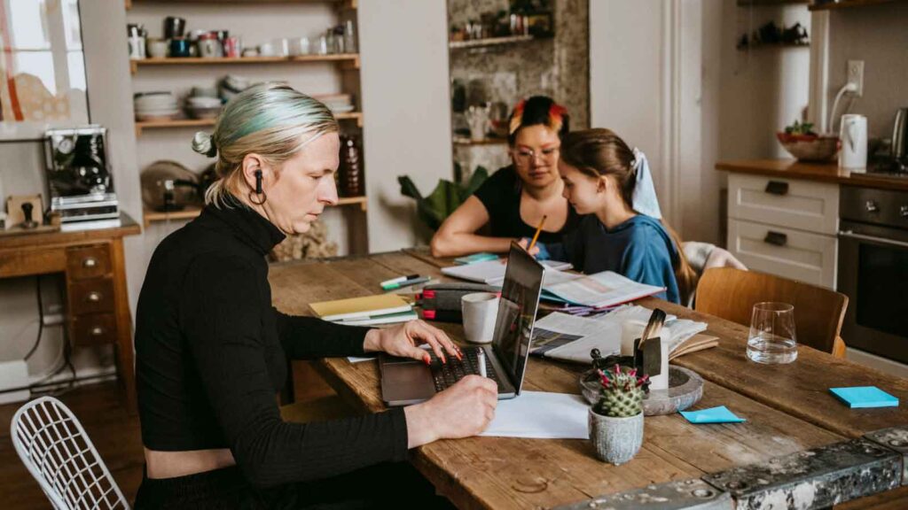 A family working together on paperwork in a bright, modern kitchen.