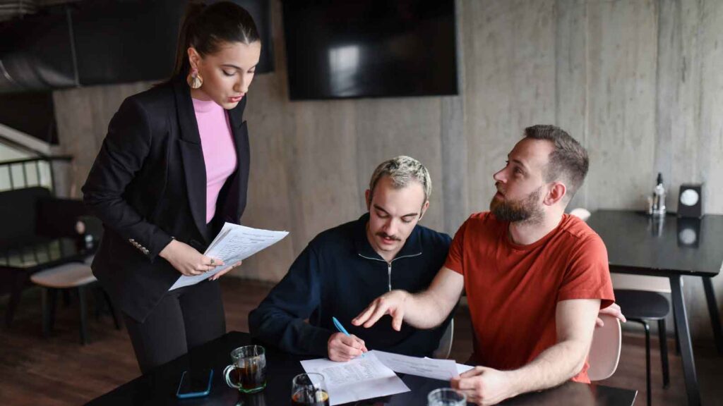 A couple talking with a lawyer in a professional office setting.