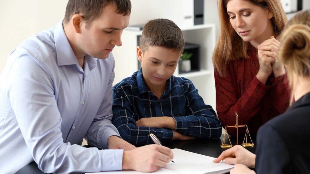 A family engaged in a discussion inside a modern, professional office setting.